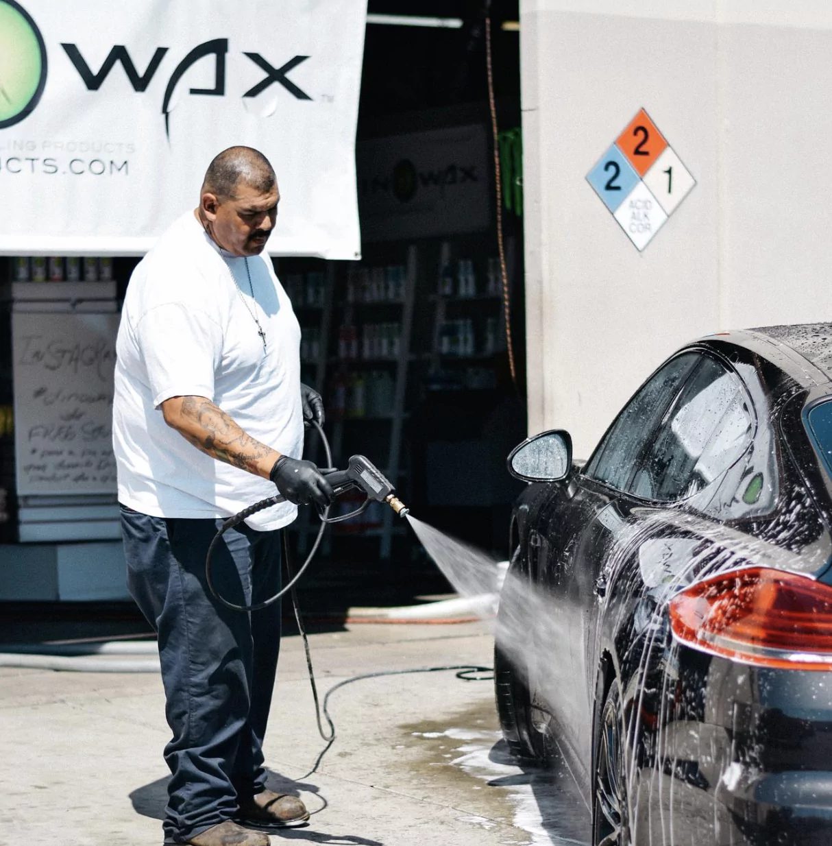A detailer applying Dinowax product to a car